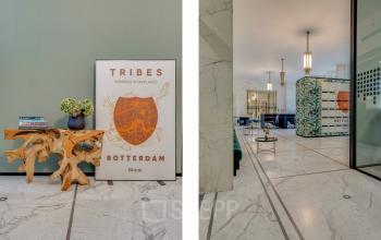 Stijlvolle entree van een kantoorpand op Blaak 34, Rotterdam Centrum, met moderne kunst, marmeren vloer en een uitnodigende sfeer. Het is een ideale plek voor kantoorruimte huren.