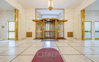 Entree van kantoorpand Blaak 34 in Rotterdam Centrum, met marmeren vloeren en een indrukwekkende gouden draaideur. Ideaal voor bedrijven die kantoorruimte willen huren in een prestigieuze omgeving.