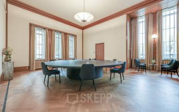 Vergaderruimte in een kantoorpand aan Blaak 34 in Rotterdam Centrum, met een grote vergadertafel en stoelen. Geschikt voor kantoorruimte huren.