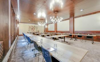 Interieur van een ruime vergaderruimte op Blaak 34 in Rotterdam Centrum met houten afwerking en lange tafels, ideaal voor kantoorruimte huren.