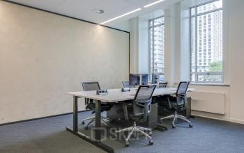Kantoorruimte huren in Rotterdam Centrum, Blaak 34. Gemeubileerd kantoor met meerdere bureaus en bureaustoelen, groot raam met uitzicht op de stad.