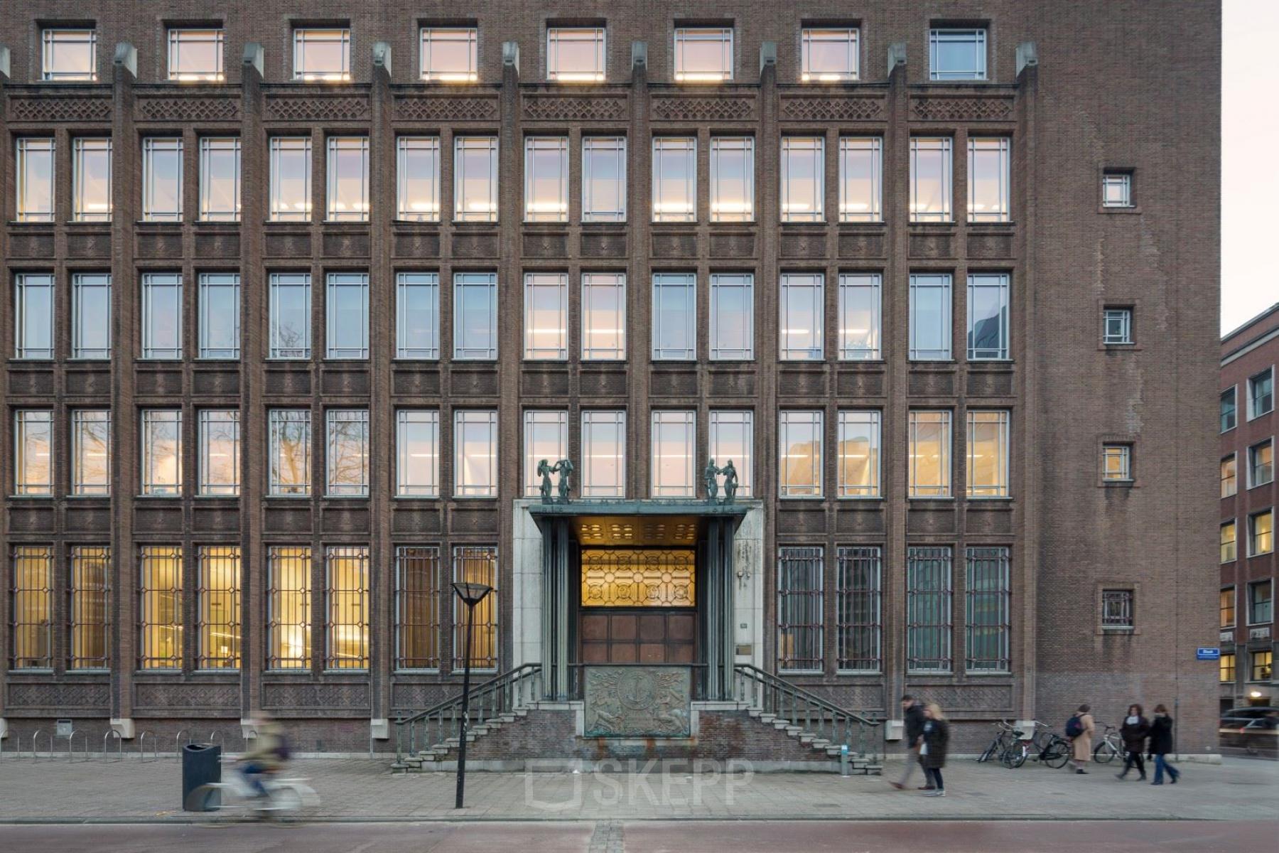 Exterieur van het kantoorpand gelegen aan Blaak 34 in Rotterdam Centrum, met karakteristieke architectuur en meerdere personen die langs het gebouw lopen.