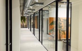 Modern kantoorpand op Westblaak 90, Rotterdam Centrum met glazen wanden en zicht op meerdere werkruimtes. Voorzien van industriële afwerking en groene planten.
