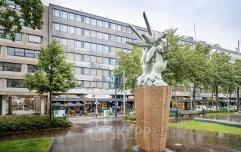 Exterieur van kantoorpand Westblaak 109 in Rotterdam Centrum met een opvallend standbeeld op de voorgrond.