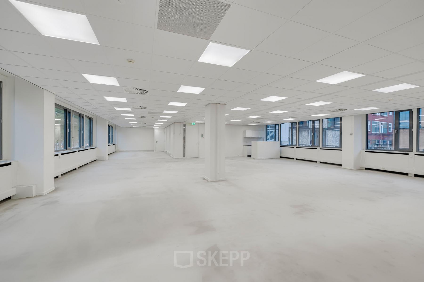 Ruime en lichte kantoorruimte met veel ramen op Westblaak 109 in Rotterdam Centrum. Kantoorruimte huren met moderne plafondverlichting en neutraal interieur