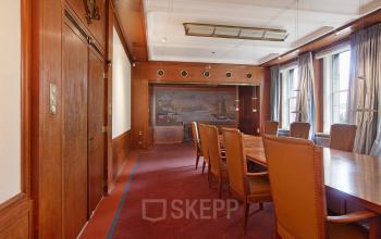 Stijlvolle vergaderruimte in kantoorpand aan Schiekade 830, Rotterdam Centrum, met lange tafel en lederen stoelen.