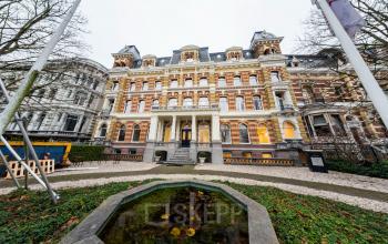 Kantoorpand Westplein 12 in Rotterdam Centrum met klassieke gevel, omgeven door groen en een kleine vijver.