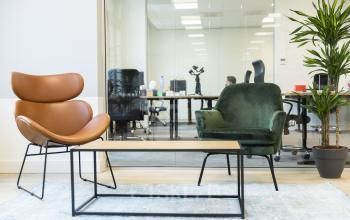 Stijlvolle kantoorruimte huren bij Westplein 12, Rotterdam Centrum. Moderne inrichting met comfortabele stoelen en glazen wand die kantoorruimte scheidt. Zakelijk overleg achter glazen wand.