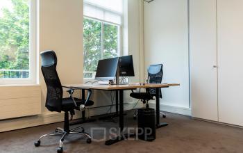 Moderne kantoorruimte huren aan Westplein 12 in Rotterdam Centrum met twee bureaus, stoelen, en computers voor zakelijke activiteiten.