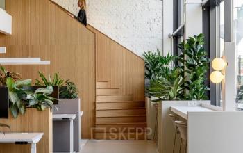 Moderne kantoorruimte huren in kantoorpand op Vasteland 42-110, Rotterdam Centrum met lichtinval, houten trap en planten.