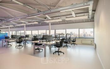 Moderne, goed verlichte kantoorruimte met bureaus en stoelen in kantoorpand aan Vasteland 42-110, Rotterdam.