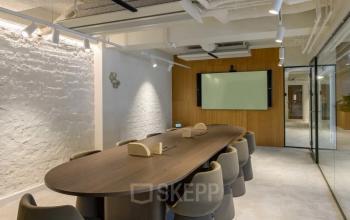 Moderne vergaderruimte in kantoorpand Vasteland 42-110, Rotterdam Centrum, met houten tafel en comfortabele stoelen, glazen muur en presentatiescherm, geschikt voor kantoorruimte huren.