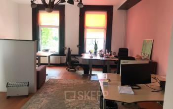 Kantoorruimte huren op Schiekade 105, Rotterdam Centrum. Gemeubileerde ruimte met bureaus, stoelen en computers in een lichte omgeving met grote ramen.