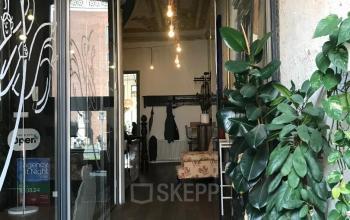 Entree van kantoorpand op Schiekade 105, Rotterdam Centrum, met houten vloeren, grote planten en verlichting aan het plafond.