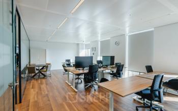 Moderne kantoorruimte in Rotterdam op Weena 788 met houten vloeren en strakke inrichting, ideaal om te huren. Het biedt ruime werkplekken met daglicht, geschikt voor productief werken.