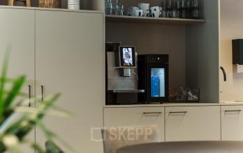 Gezellige pantry in kantoorpand op Weena 788, met moderne koffiemachine en stijlvolle opbergkasten. Beschikbare kantoorruimte huren biedt een functionele en uitnodigende omgeving in het centrum van Rotterdam.