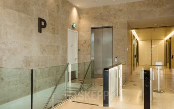 Modern kantoorpand in Rotterdam Centrum, Weena 788. Ruimte met glazen balustraden en liften, ideaal voor kantoorruimte huren. Stijlvol, met lichte tinten en een professionele uitstraling.