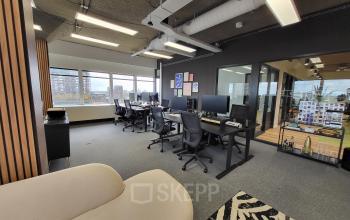 Modern kantoorpand aan Aert van Nesstraat 45 in Rotterdam Centrum met werkplekken, bureaus en stoelen, ideaal voor kantoorruimte huren.