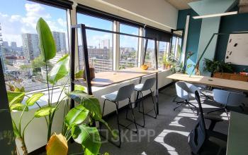 Kantoorruimte huren aan Aert van Nesstraat 45 in Rotterdam Centrum met grote ramen, planten en bureaus, biedt een lichte werkomgeving.