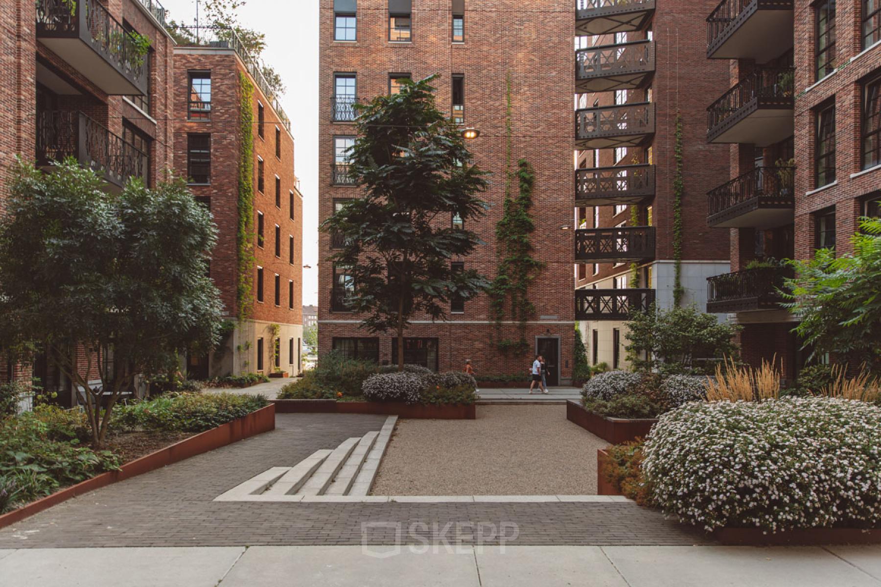 Bakstenen kantoorpand te huur aan Karl Weisbardstraat 181 - 201, Rotterdam Centrum, met groene binnenplaats en moderne architectuur.