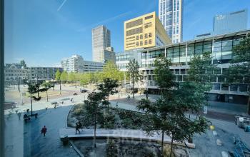 Uitzicht op het exterieur van Kruisplein 480, gelegen in het bruisende centrum van Rotterdam. Geschikt voor huur als modern kantoorpand, omringd door groene ruimtes en stedelijke voorzieningen.