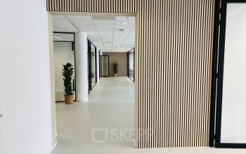 Interieur van modern kantoorpand op Kruisplein 480 in Rotterdam Centrum, met glazen wanden en planten, geschikt voor werkruimten. Kantoorruimte huren met een frisse uitstraling.