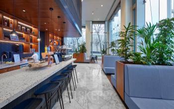 Moderne en licht ingerichte kantoorruimte op Blaak 555 in Rotterdam Centrum, met hoge ramen en een stijlvolle koffiebar omringd door zitruimtes. Ideale plek voor een kantoorruimte huren.