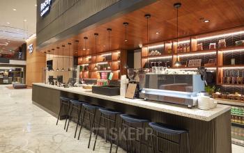 Moderne koffieruimte in kantoorpand Blaak 555, Rotterdam Centrum met stijlvolle bar en krukken, ideaal voor koffiepauzes tijdens kantoorruimte huren.