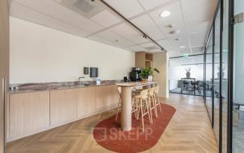 Moderne kantoorruimte op Blaak 555 in Rotterdam Centrum, met een stijlvolle pantry en vergaderruimte zichtbaar. Ideaal voor wie een kantoorpand wil huren met een creatieve en functionele inrichting.