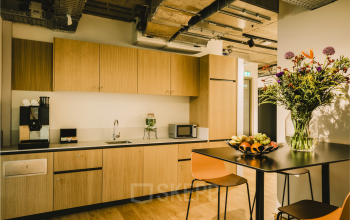 Moderne pantry in kantoorpand op Coolsingel 65, Rotterdam Centrum, met keukenfaciliteiten en zithoek, ideaal voor een pauze tijdens het kantoorruimte huren.