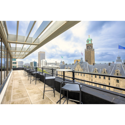 Uitzicht op het dakterras van een kantoorpand aan Coolsingel 65 in Rotterdam Centrum, zonder mensen, met moderne barstoelen en een panoramisch uitzicht over de stad.