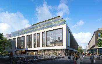 Modern kantoorpand op Hoogstraat 185 in Rotterdam Centrum, met fietsenstalling en enkele mensen buiten het gebouw.