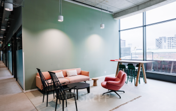 Moderne en lichte kantoorruimte huren in een kantoorpand op Hoogstraat 185, Rotterdam Centrum, met comfortabele meubels, grote ramen en uitnodigende zithoek.