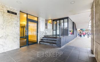 Ingang van kantoorpand Weena 87 in Rotterdam Centrum met glazen deuren en marmeren muren. Mensen lopen op de achtergrond. Ideale locatie voor kantoorruimte huren in het levendige centrum van Rotterdam.