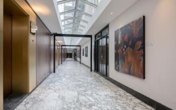 Heldere gang met glazen plafond en marmeren vloer in kantoorpand Weena 87, Rotterdam Centrum, ideaal voor kantoorruimte huren.