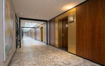 Moderne gang met marmeren vloer in kantoorpand op Weena 87, Rotterdam Centrum. Ideaal voor bedrijven die kantoorruimte willen huren in een professionele omgeving.