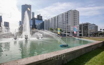 Uitzicht op moderne kantoorpanden aan de Weena 87 in Rotterdam Centrum met omliggende gebouwen en fonteinen in een stedelijke setting. Ideale locatie voor kantoorruimte huren in een bruisende omgeving.