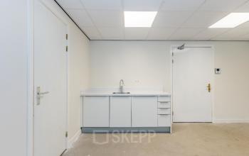 Kantoorpand Weena 87 in Rotterdam Centrum met modern ingerichte pantry voorzien van witte kasten en spots. Ideaal voor bedrijven die kantoorruimte willen huren op een centrale locatie.