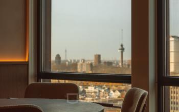 Gezellig ingerichte kantoorruimte op Coolsingel 139, Rotterdam Centrum, met grote ramen en uitzicht op de skyline. Ideaal om te huren voor inspirerende werkmomenten.