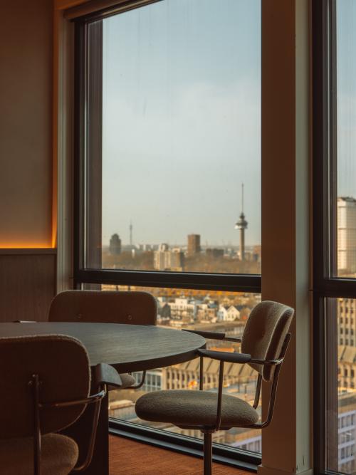 Gezellig ingerichte kantoorruimte op Coolsingel 139, Rotterdam Centrum, met grote ramen en uitzicht op de skyline. Ideaal om te huren voor inspirerende werkmomenten.