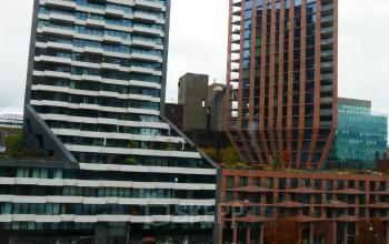 Uitzicht op moderne kantoorpanden aan Wijnhaven 76 in Rotterdam Centrum met opvallende architectuur en omliggende omgeving. Geschikt voor kantoorruimte huren nabij het water.