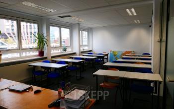 Kantoorruimte huren aan Wijnhaven 76 in Rotterdam Centrum met meerdere bureaus en stoelen, geschikt voor werkplekken. Grote ramen zorgen voor veel natuurlijk licht.