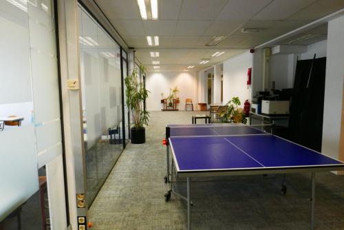 Interieur van een kantoorpand op Wijnhaven 76 in Rotterdam Centrum met een tafeltennistafel en planten langs de gang. Kantoorruimte huren in dit gebouw biedt een speelse en functionele omgeving.