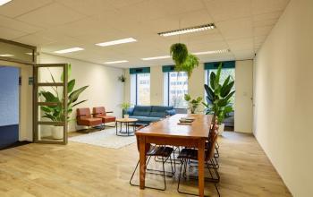 Moderne kantoorruimte in kantoorpand op Westblaak 92, Rotterdam Centrum, met houten vloeren, comfortabele zitplekken en groene planten.