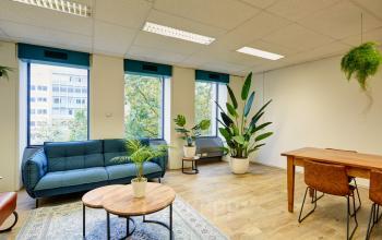 Moderne en lichte kantoorruimte met comfortabele zitbank en houten tafel, gelegen op Westblaak 92 in Rotterdam Centrum.