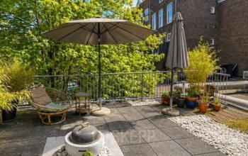 Dakterras van kantoorpand op Mauritsweg 33 A01 in Rotterdam Centrum, met parasols, planten en een zitgedeelte. Geschikt voor kantoorruimte huren met ontspanningsmogelijkheden buiten.