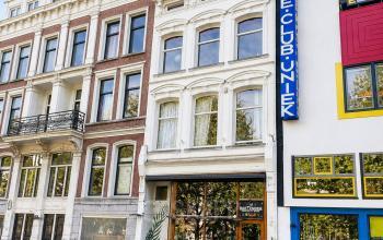 Gevels van historische panden aan de Mauritsweg in Rotterdam Centrum met daaronder een kleine buitenruimte met tafels en stoelen voor casual zakelijke bijeenkomsten.