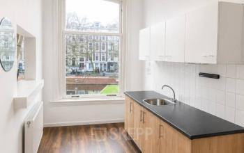 Kantoorruimte Rotterdam Centrum op Mauritsweg 33 A01 met uitzicht op de straat, beschikt over een kitchenette met houten kastjes en witte tegels, geschikt voor huren.