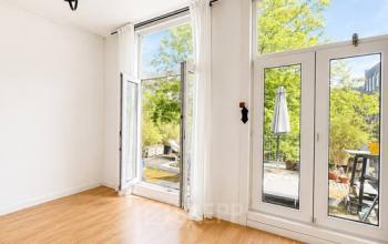 Lichte kantoorruimte met houten vloer, grote ramen en zicht op groen, ideaal voor kantoorruimte huren. Gelegen op Mauritsweg 33 A01 in Rotterdam Centrum.
