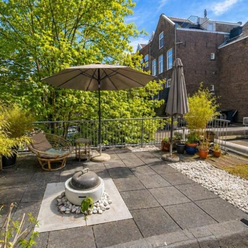 Dakterras van kantoorpand op Mauritsweg 33 A01 in Rotterdam Centrum, met parasols, planten en een zitgedeelte. Geschikt voor kantoorruimte huren met ontspanningsmogelijkheden buiten.